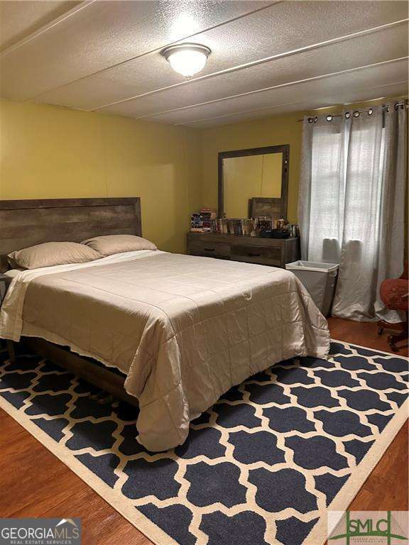 219 John Carter Road Bloomingdale, GA 31302 - Photo 9 of 28 a bedroom with a bed and wooden floor