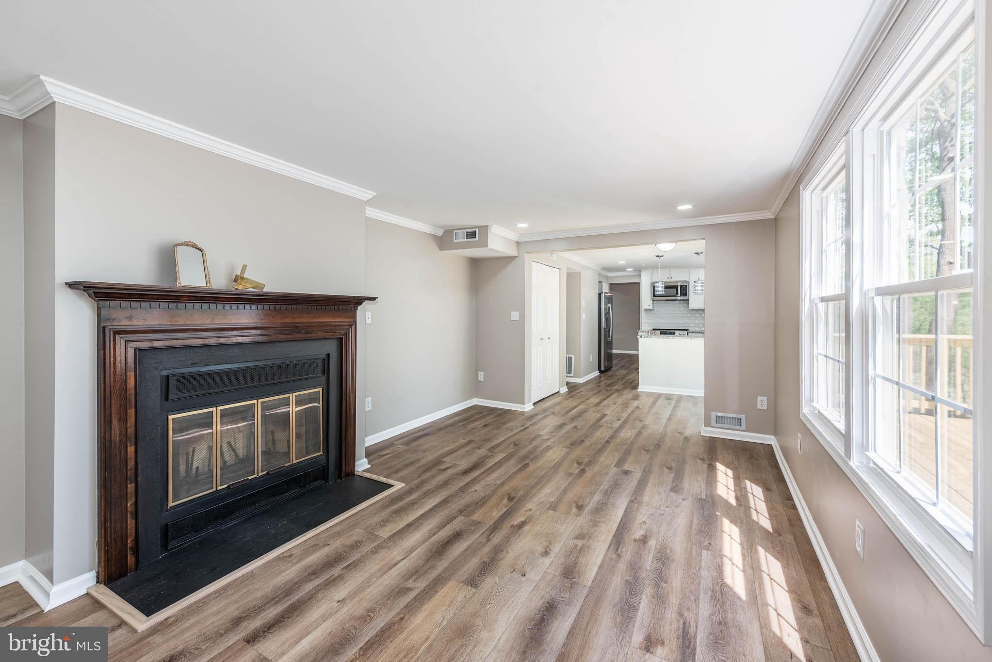 7674 Tuckerman Drive Hanover, MD 21076 - Photo 13 of 45 a view of an empty room with wooden floor fireplace and a window