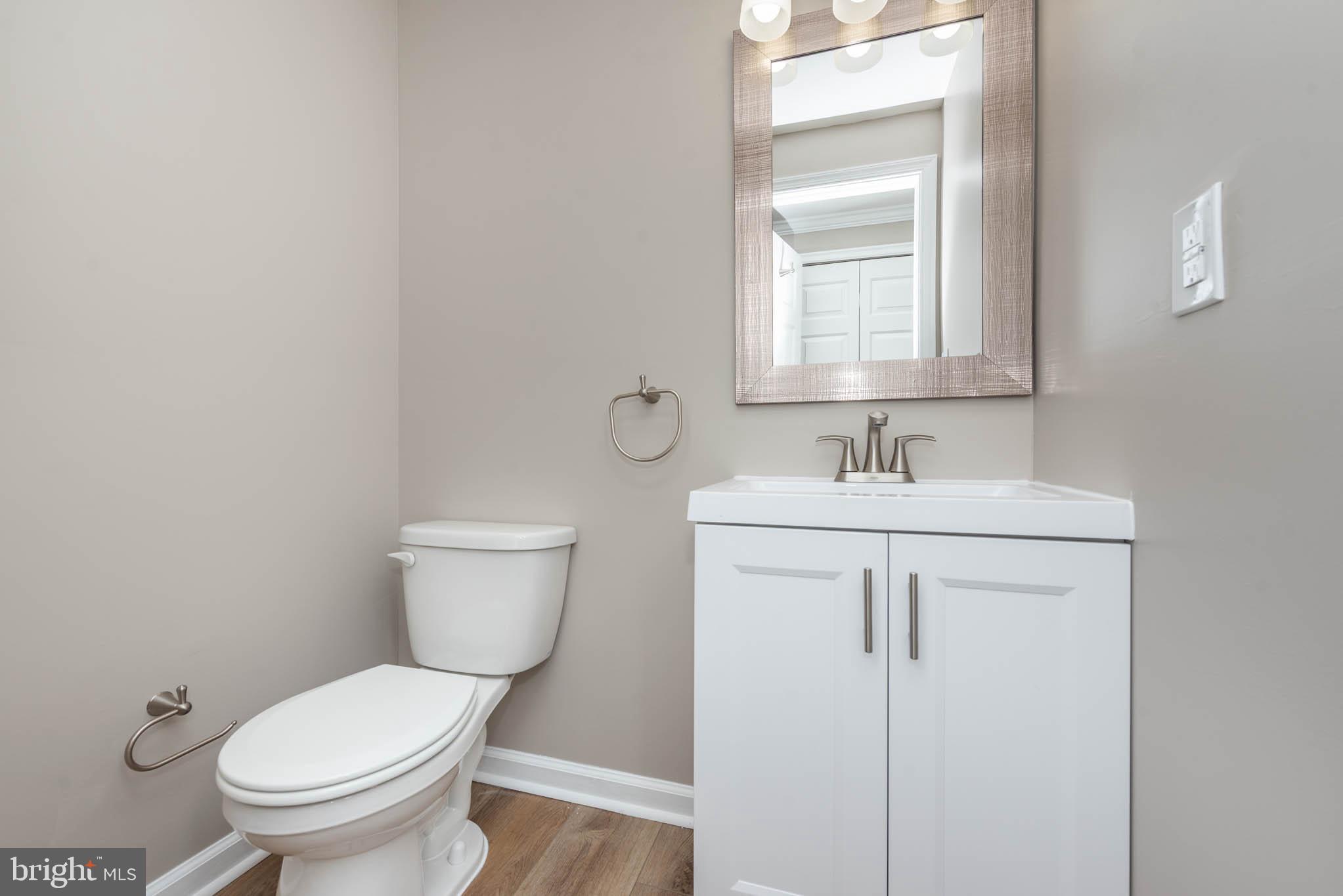 7674 Tuckerman Drive Hanover, MD 21076 - Photo 14 of 45 a bathroom with a toilet sink and mirror