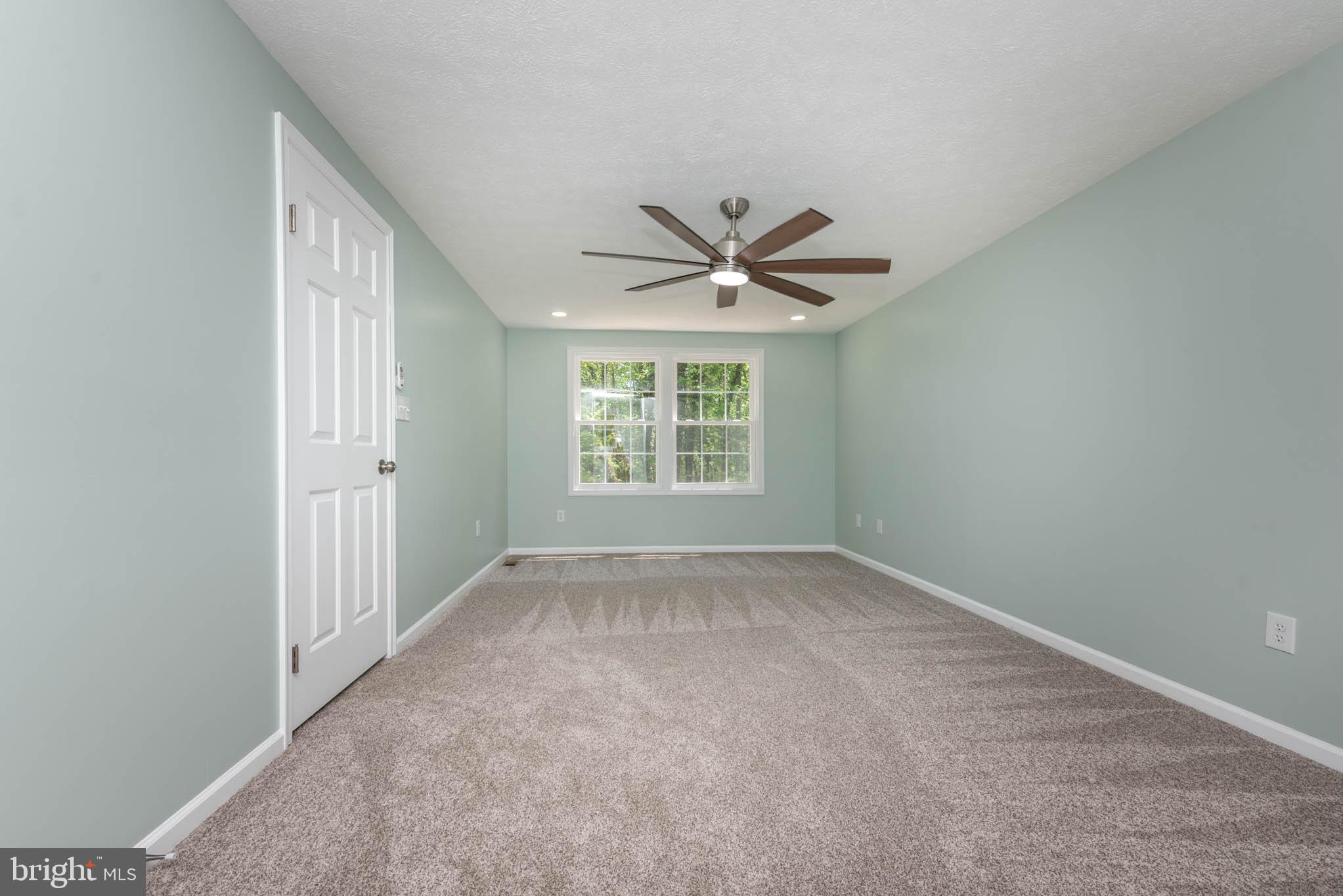 7674 Tuckerman Drive Hanover, MD 21076 - Photo 17 of 45 an empty room with a window and a fan