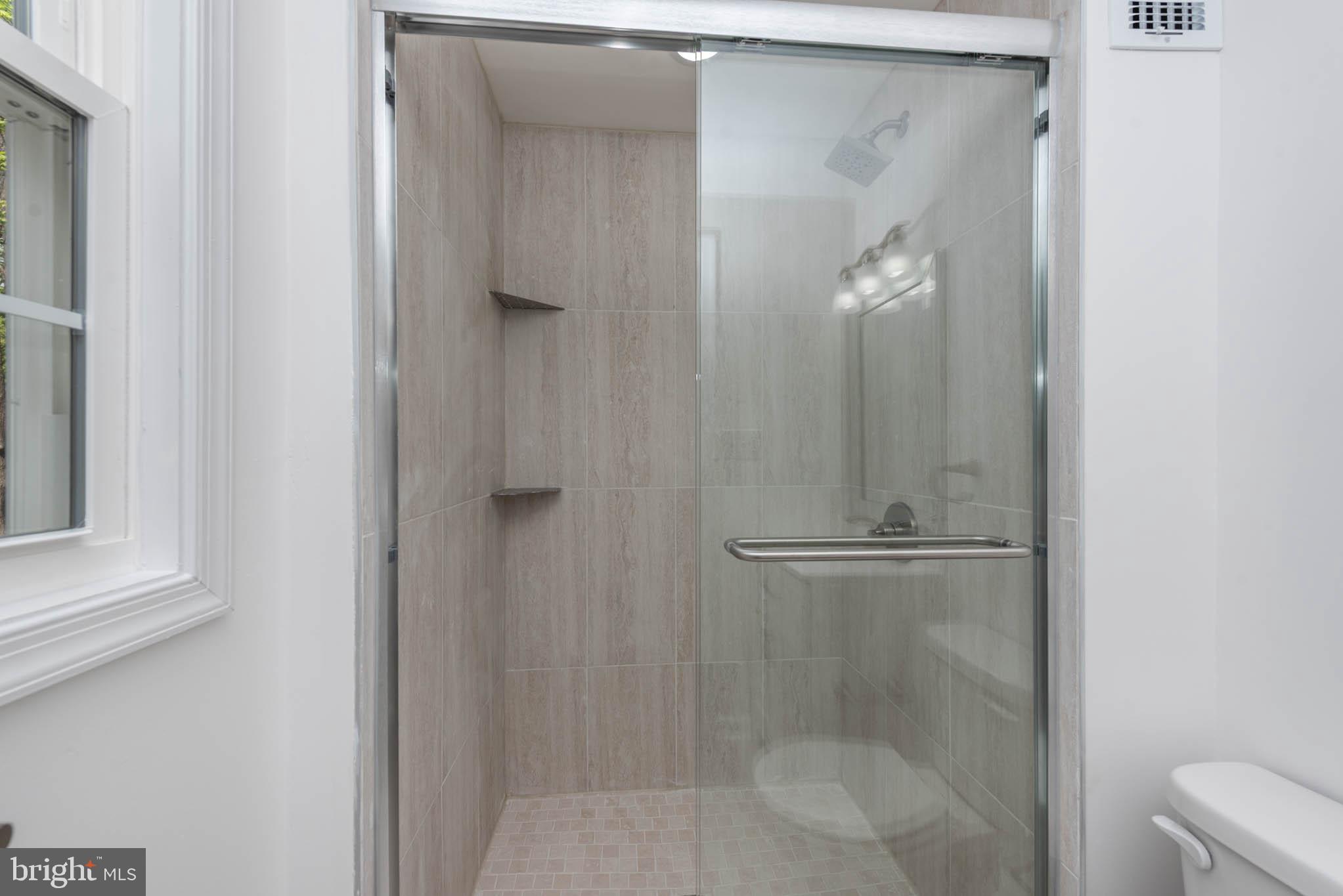 7674 Tuckerman Drive Hanover, MD 21076 - Photo 21 of 45 a bathroom with a glass shower door