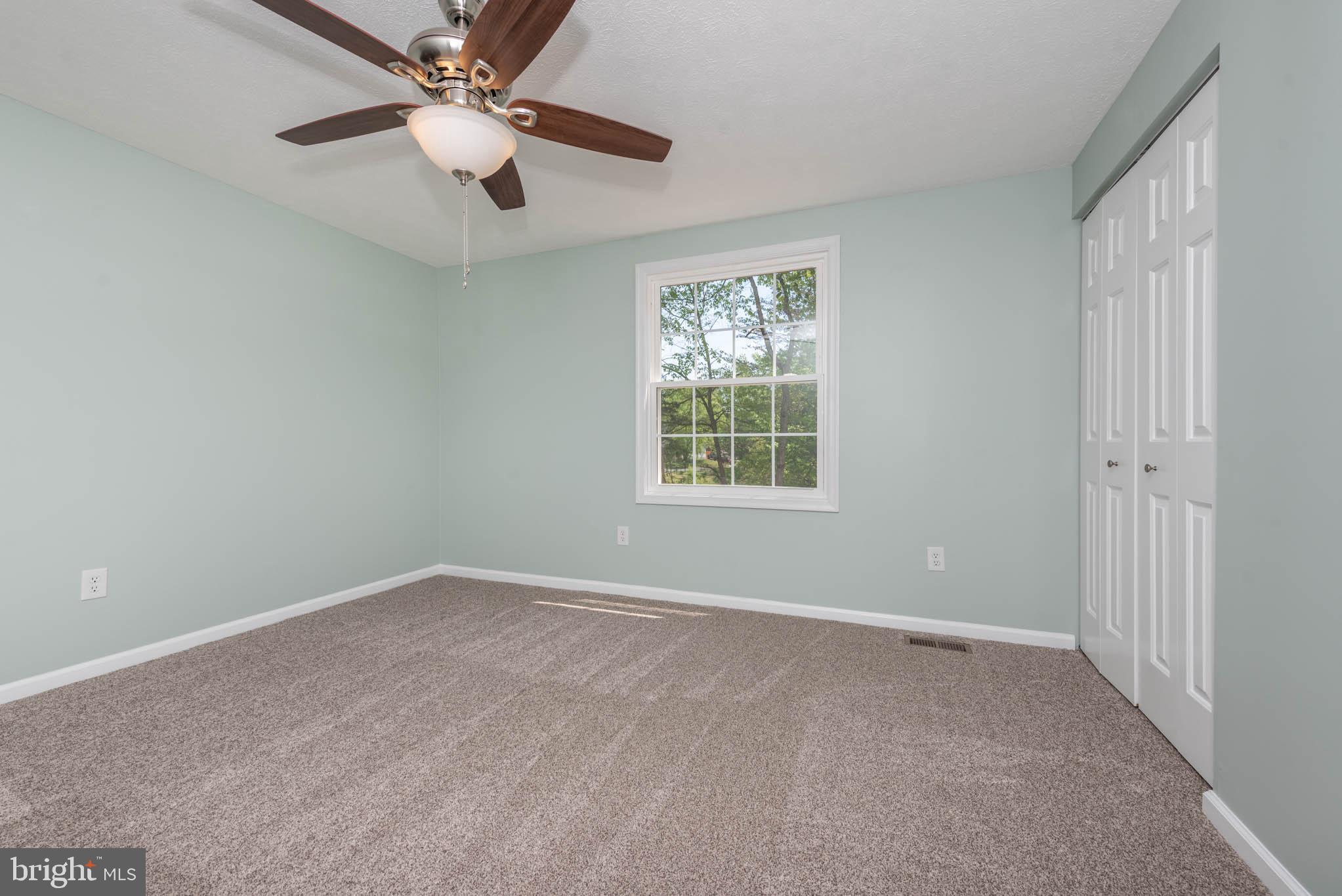 7674 Tuckerman Drive Hanover, MD 21076 - Photo 24 of 45 an empty room with a window and a fan