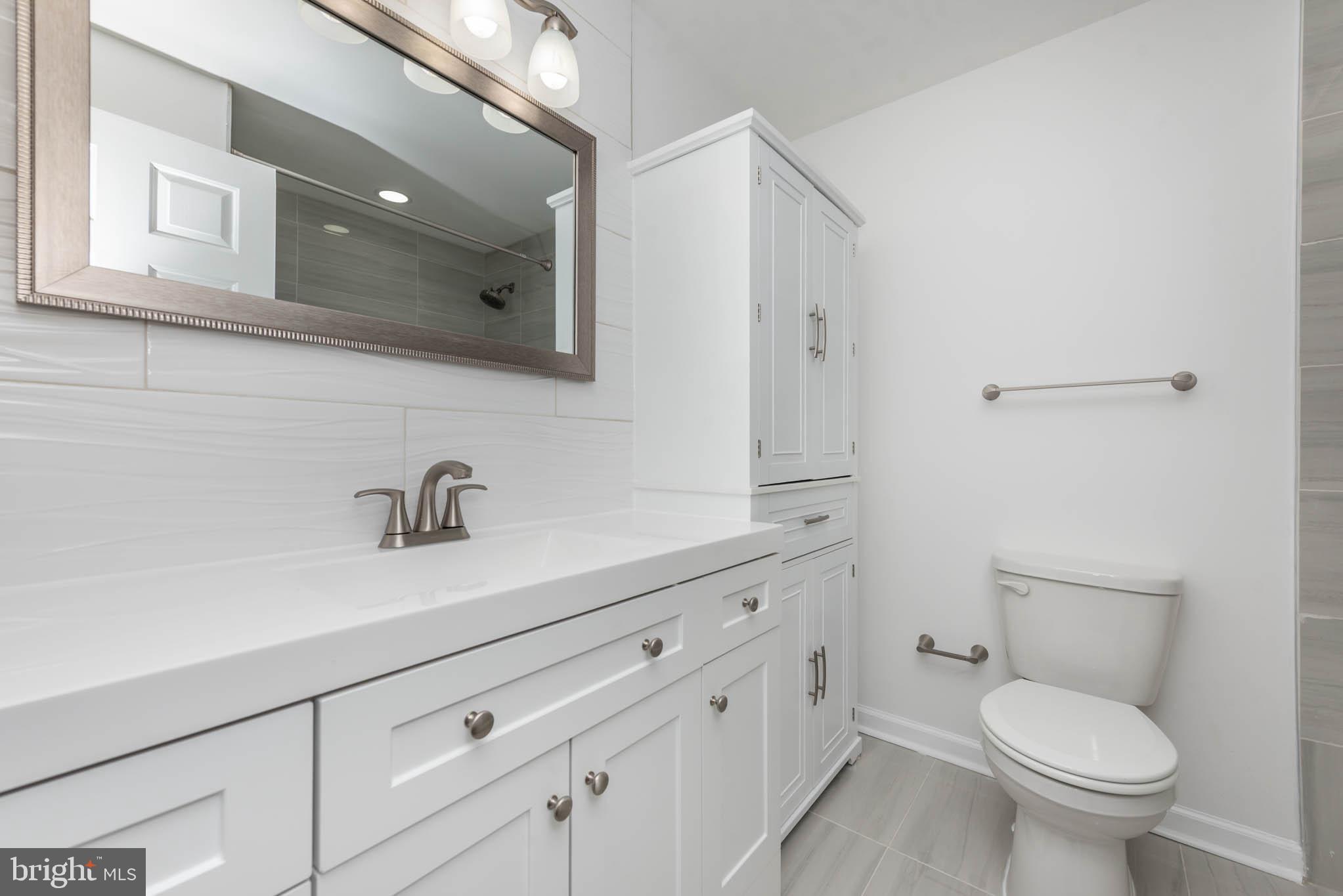7674 Tuckerman Drive Hanover, MD 21076 - Photo 27 of 45 a bathroom with a toilet sink and mirror