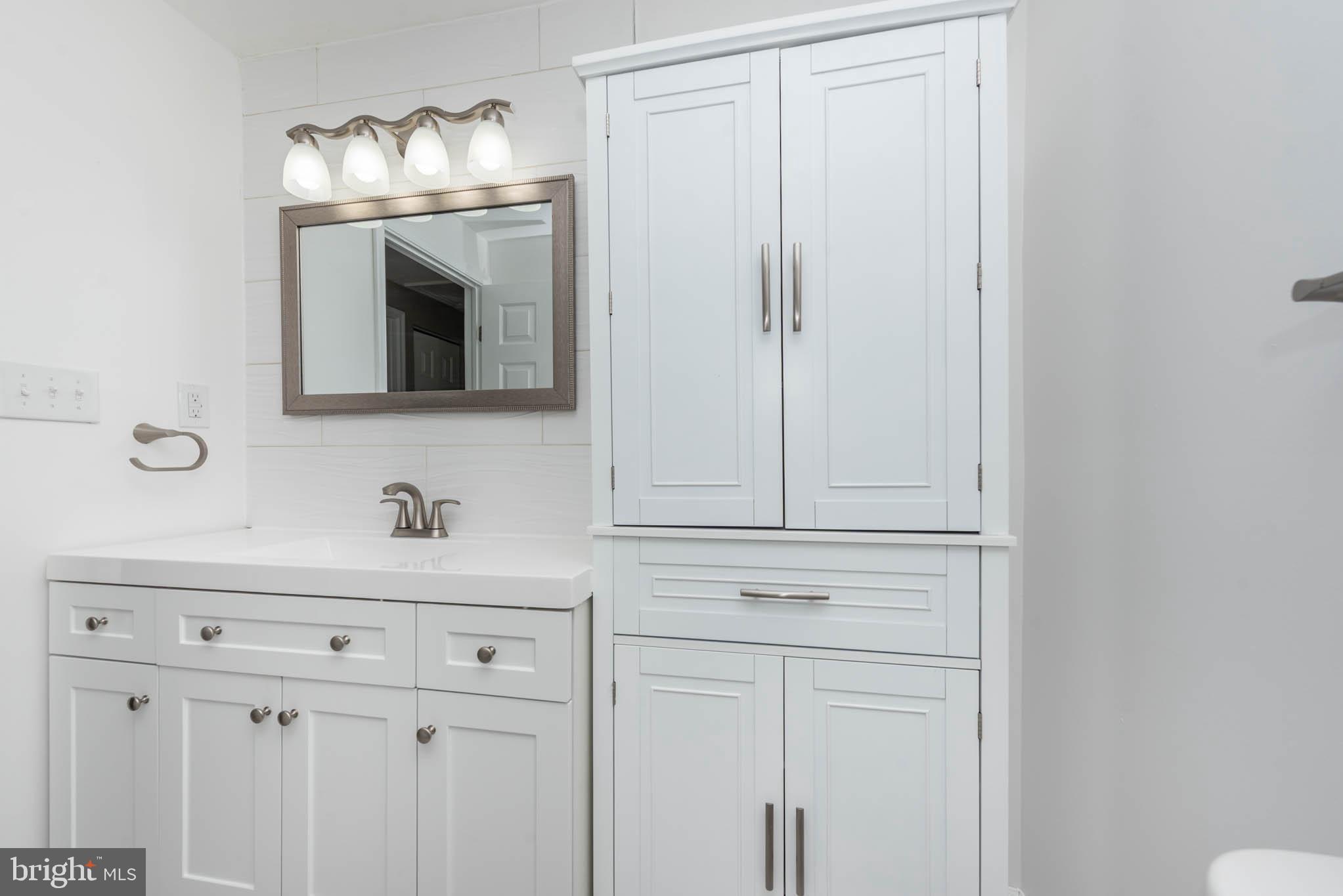 7674 Tuckerman Drive Hanover, MD 21076 - Photo 28 of 45 a bathroom with a sink vanity and mirror