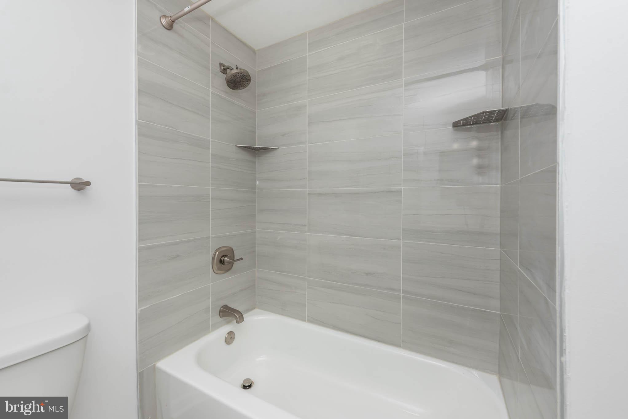 7674 Tuckerman Drive Hanover, MD 21076 - Photo 29 of 45 a bathroom with a white bath tub a shower and a sink