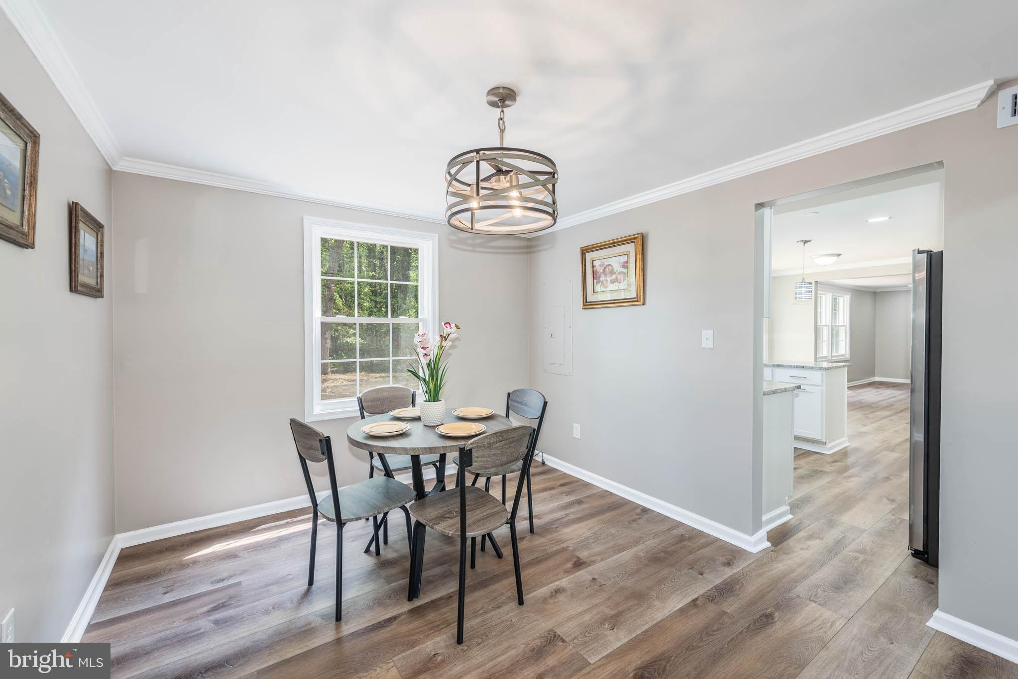 7674 Tuckerman Drive Hanover, MD 21076 - Photo 6 of 45 a view of a dining room with furniture window and wooden floor