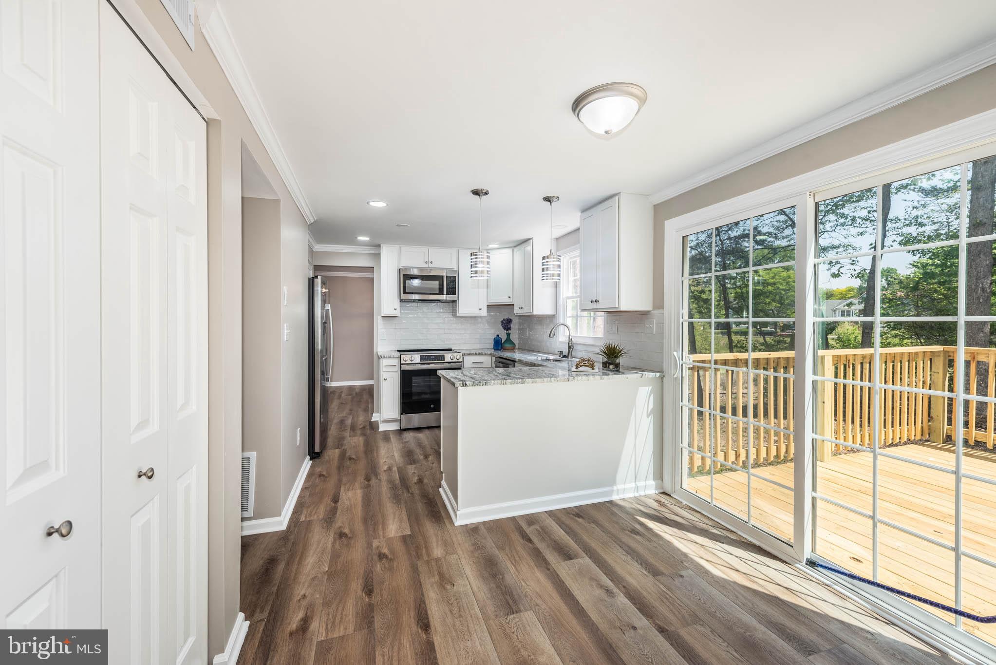 7674 Tuckerman Drive Hanover, MD 21076 - Photo 10 of 45 a kitchen with white cabinets and wooden floor