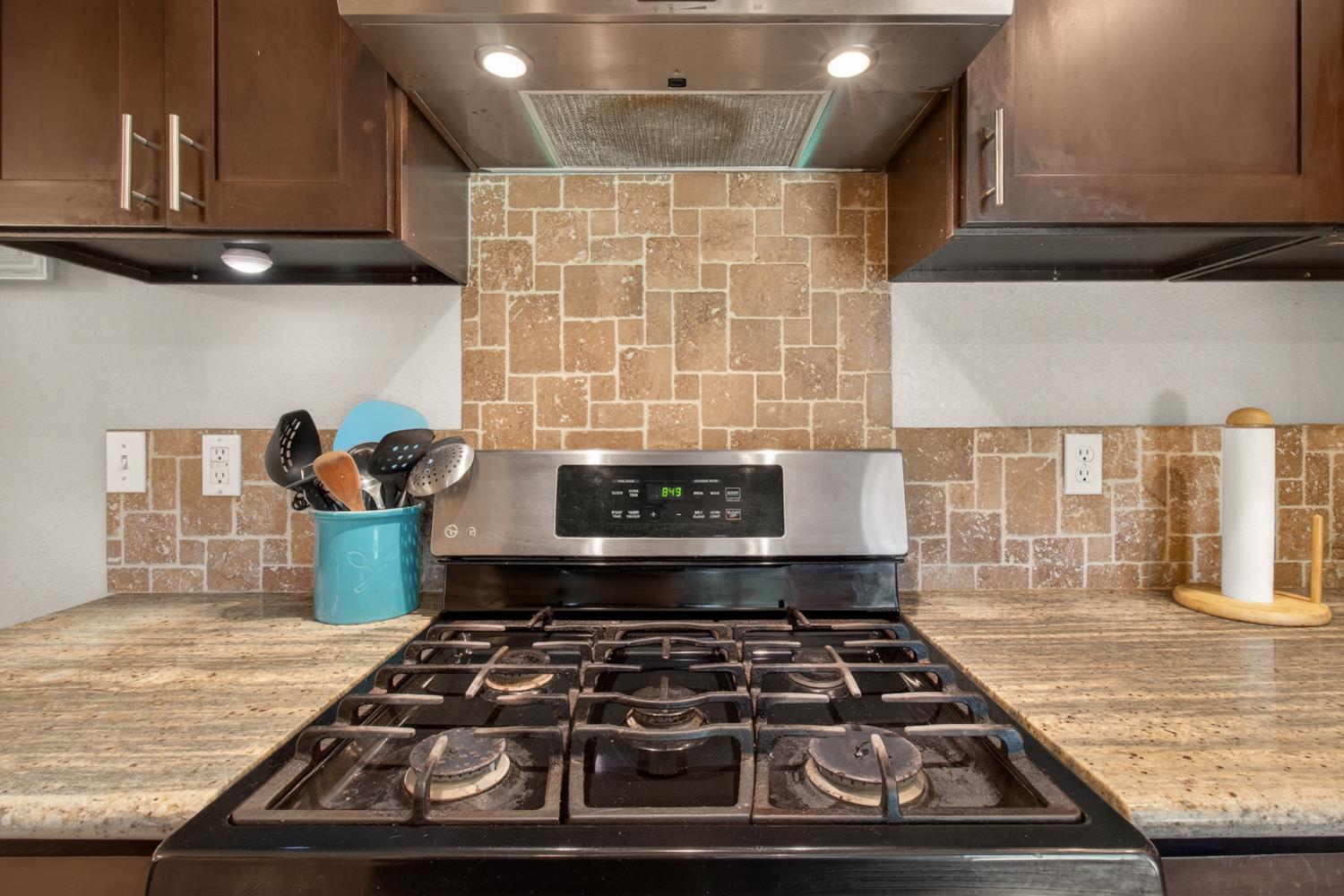 6332 Horseshoe Bar Road Loomis, CA 95650 - Photo 11 of 85 Kitchen featuring a gas range, stainless steel range hood, stone tile backsplash, and granite countertops