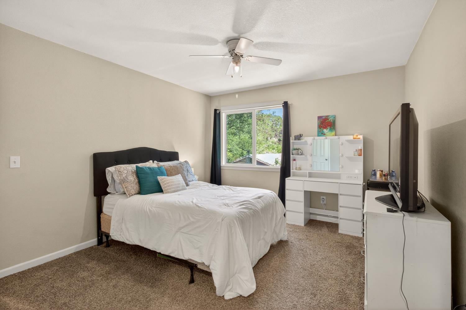 6332 Horseshoe Bar Road Loomis, CA 95650 - Photo 24 of 85 Carpeted bedroom featuring neutral wall tones, a ceiling fan, and a window with dark drapery