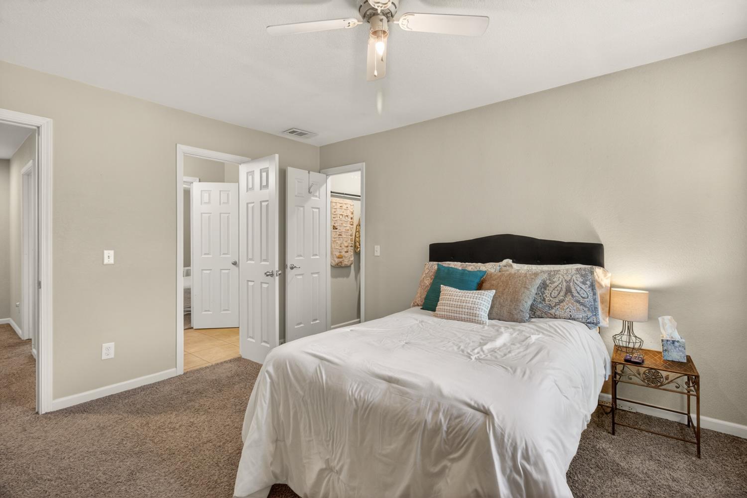 6332 Horseshoe Bar Road Loomis, CA 95650 - Photo 25 of 85 Spacious bedroom featuring neutral wall tones, plush carpet flooring, a ceiling fan with integrated lighting, and multiple paneled doors