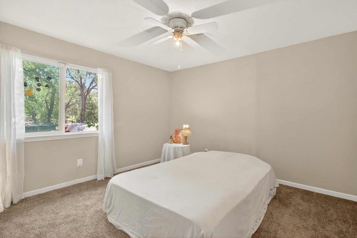 6332 Horseshoe Bar Road Loomis, CA 95650 - Photo 28 of 85 Room featuring a large window, neutral wall paint, and light brown carpet flooring