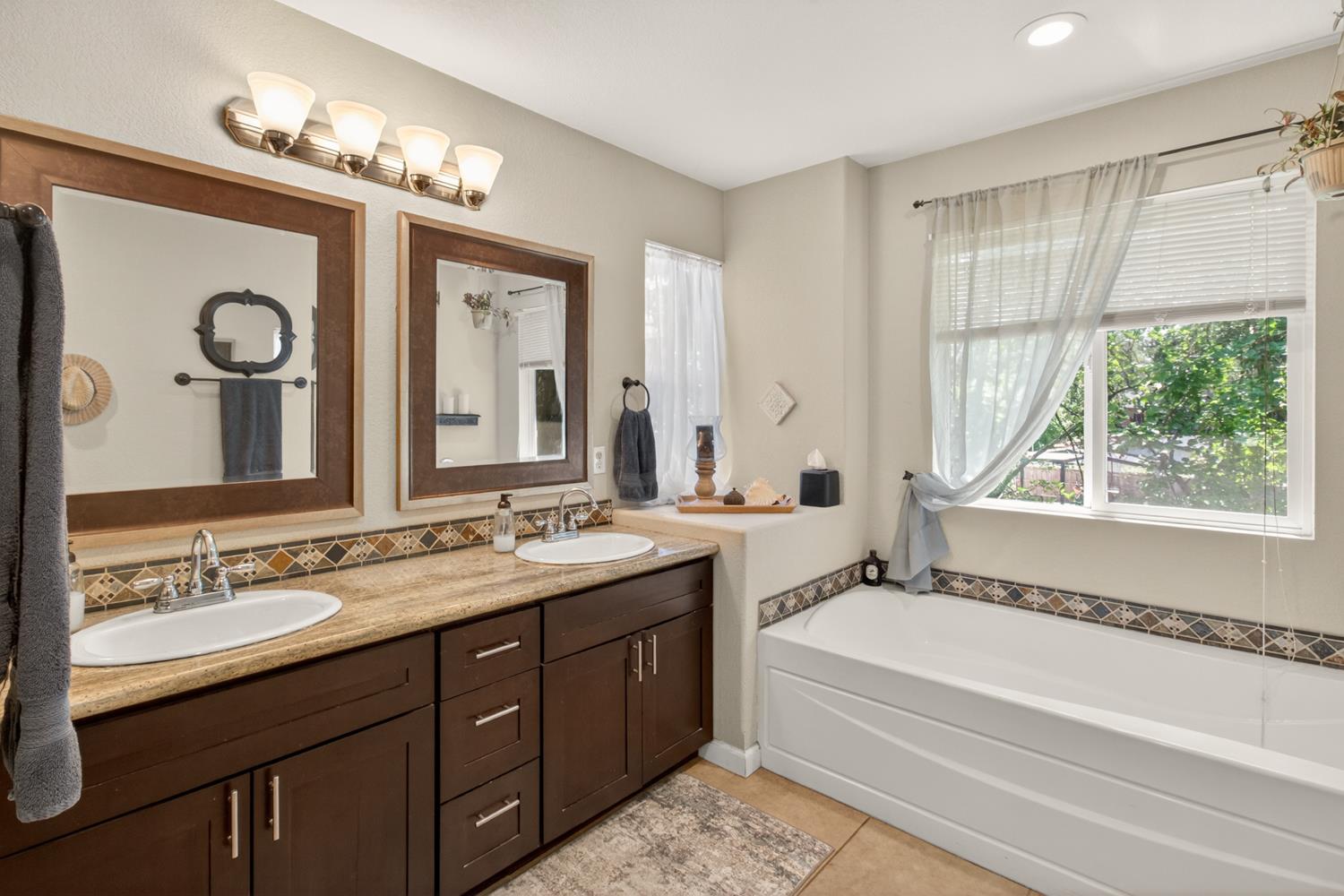 6332 Horseshoe Bar Road Loomis, CA 95650 - Photo 36 of 85 Dual vanity with dark wood-finish cabinetry, integrated sinks, and polished chrome faucets