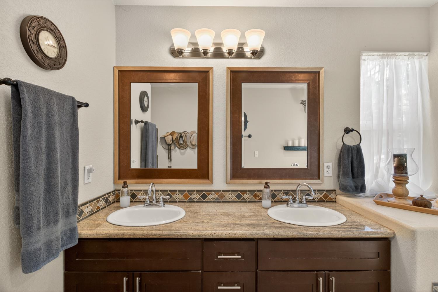 6332 Horseshoe Bar Road Loomis, CA 95650 - Photo 37 of 85 Double vanity featuring dark wood-finish cabinetry, integrated sinks, and a patterned tile backsplash