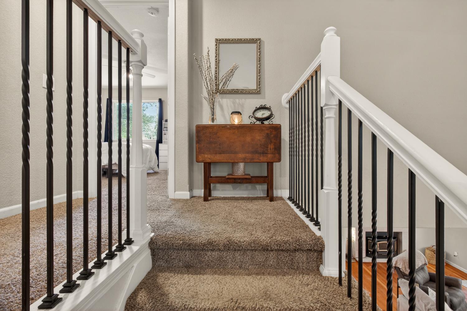 6332 Horseshoe Bar Road Loomis, CA 95650 - Photo 45 of 85 Carpeted staircase featuring white newel posts, white handrails, and black wrought iron balusters with twisted details