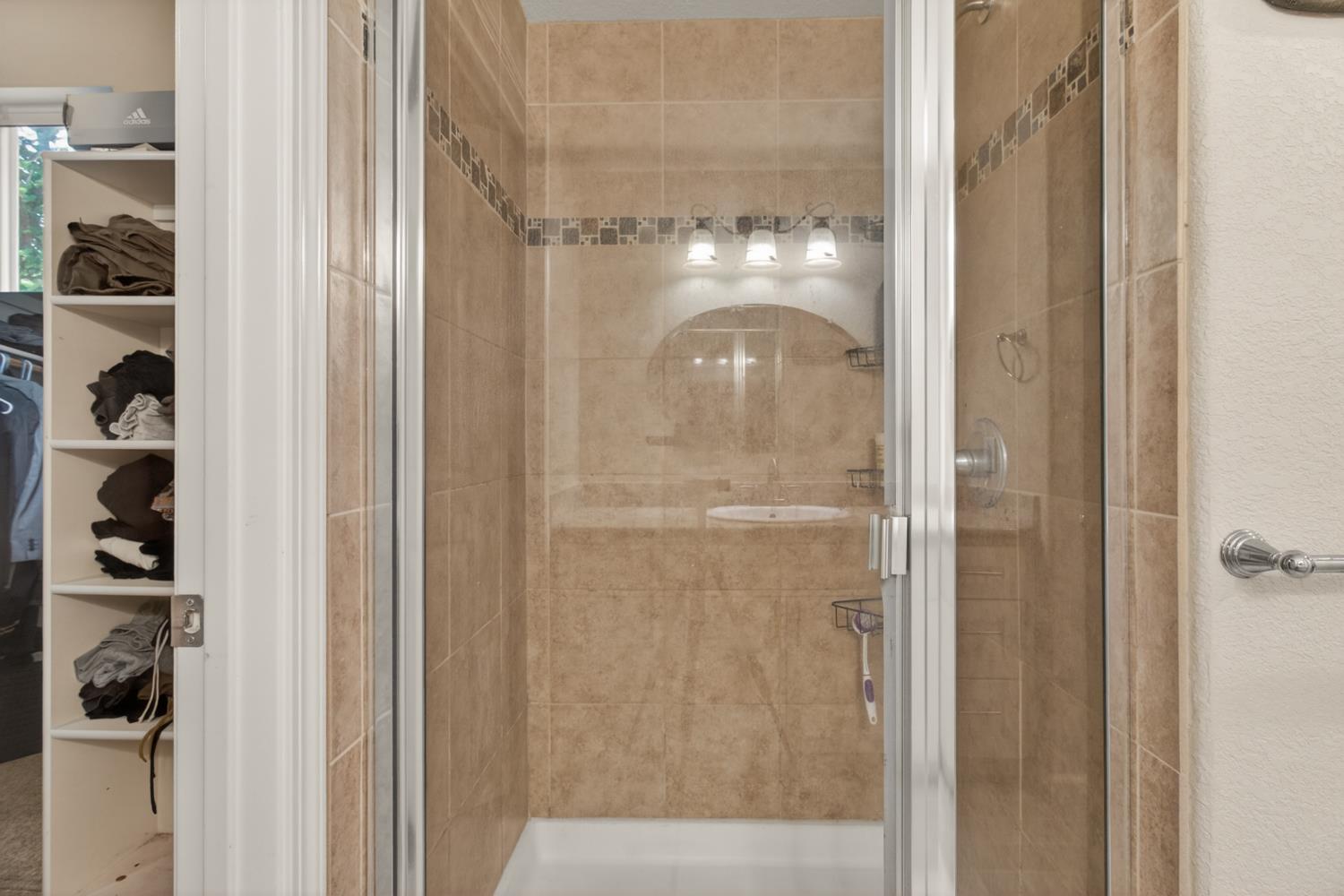 6332 Horseshoe Bar Road Loomis, CA 95650 - Photo 48 of 85 Walk-in shower featuring glass enclosure, large format tile surround, decorative mosaic tile accent, and a white shower pan