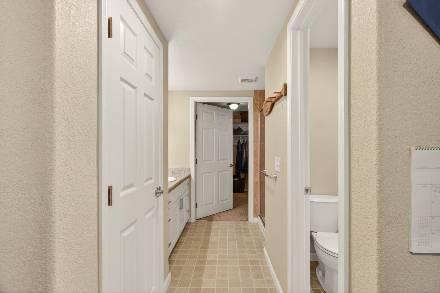 6332 Horseshoe Bar Road Loomis, CA 95650 - Photo 50 of 85 Hallway bathroom featuring a vanity with a light-colored countertop, white cabinetry, and a walk-in shower with tile surround