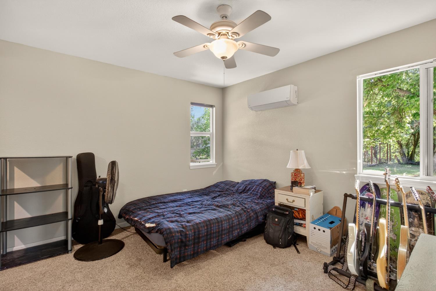 6332 Horseshoe Bar Road Loomis, CA 95650 - Photo 51 of 85 Carpeted room featuring a ceiling fan with integrated lighting, a wall-mounted mini-split HVAC unit, and two windows providing natural illumination