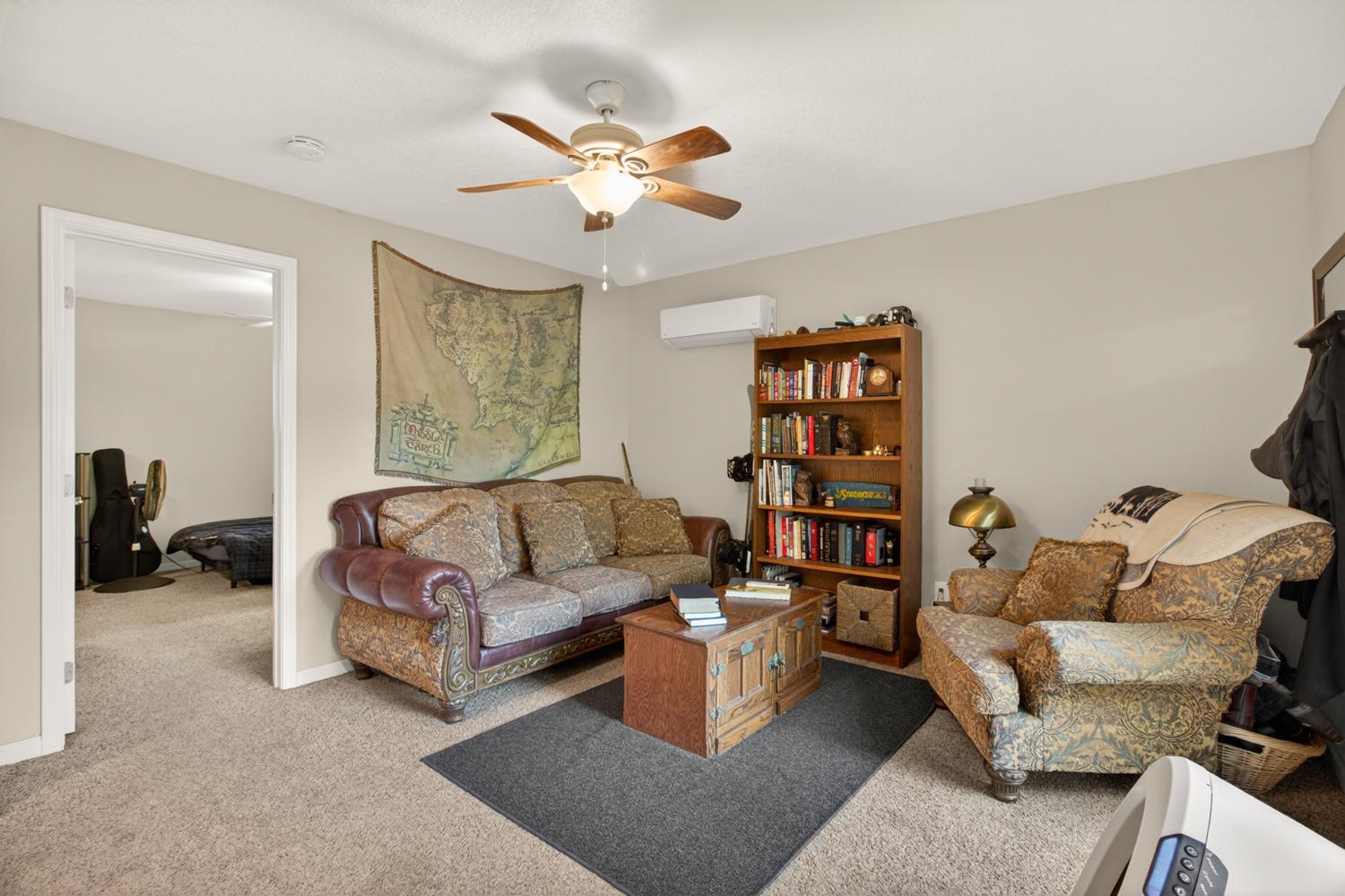 6332 Horseshoe Bar Road Loomis, CA 95650 - Photo 54 of 85 Carpeted room featuring a ceiling fan with integrated lighting, a wall-mounted mini-split HVAC unit, and a built-in bookshelf