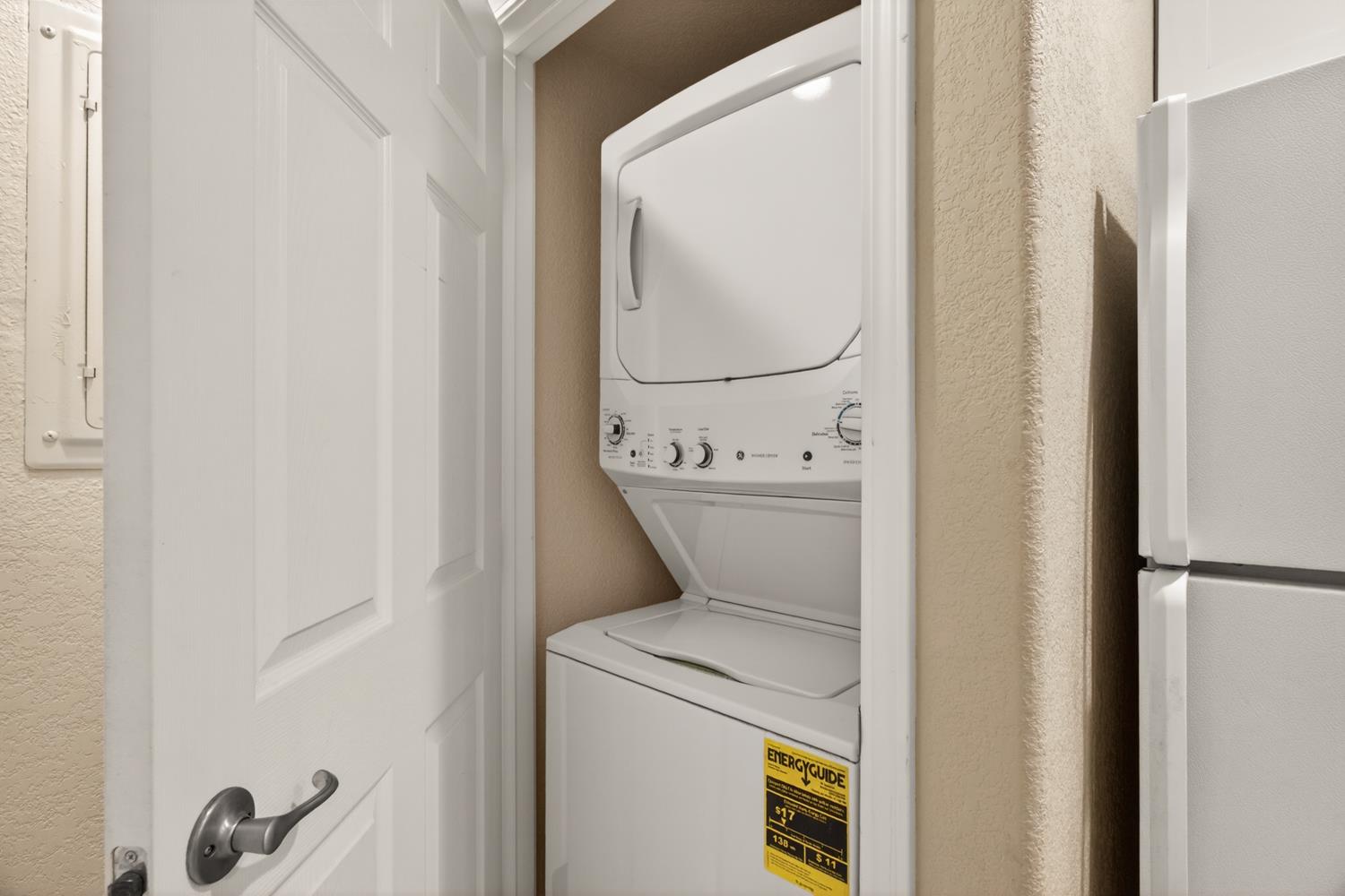 6332 Horseshoe Bar Road Loomis, CA 95650 - Photo 56 of 85 Dedicated laundry closet featuring a white stackable washer and dryer unit, complemented by neutral wall finishes