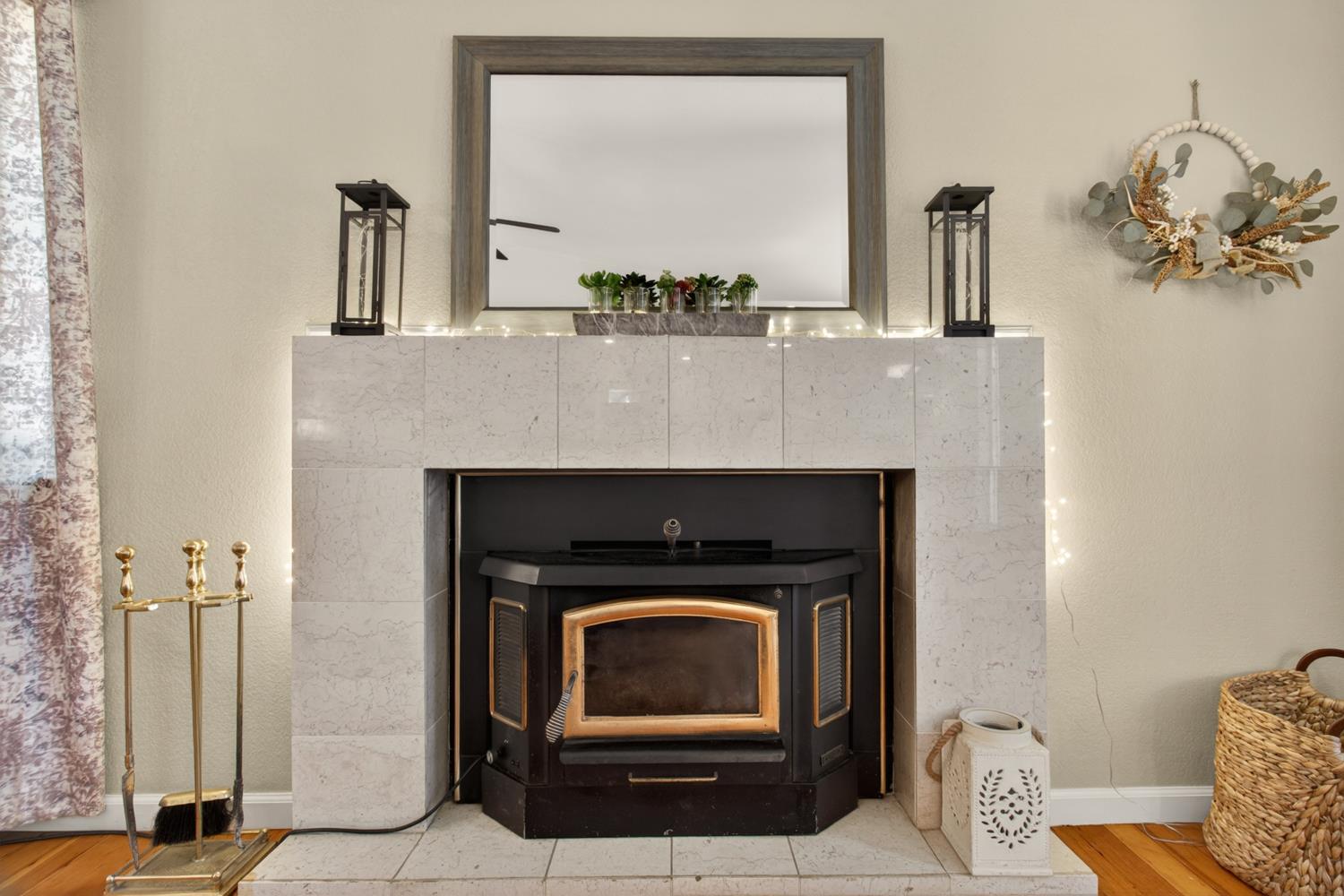 6332 Horseshoe Bar Road Loomis, CA 95650 - Photo 59 of 85 Fireplace featuring a light-toned stone surround, a black fireplace insert with gold-toned accents, a hearth with matching stone tiles, and light neutral wall paint