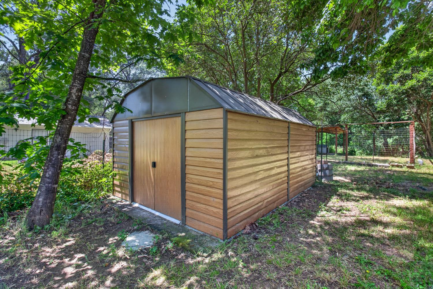 6332 Horseshoe Bar Road Loomis, CA 95650 - Photo 66 of 85 Detached storage shed featuring wood-finish siding, a curved metal roof, and double entry doors with black hardware