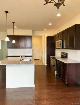 a kitchen with granite countertop a sink and a wooden floor