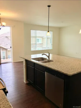 a kitchen with kitchen island granite countertop a sink and a stove