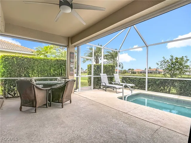 a view of a patio with a table chairs and a floor to ceiling window