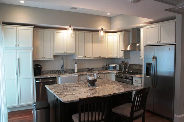 a kitchen with stainless steel appliances granite countertop a sink refrigerator and cabinets