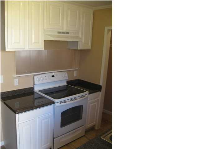 537 Hickory Avenue, Unit B Niceville, FL 32578 - Photo 9 of 19 a kitchen with granite countertop white cabinets and a stove