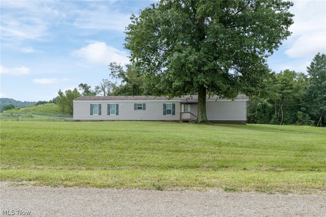 8472 Azalea Road Southwest Dennison, OH 44621 - Photo 1 of 35 Expansive green lawn with a large, mature tree providing natural shade