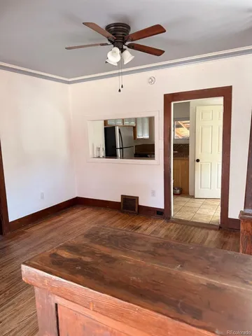 a view of a livingroom with wooden floor and a ceiling fan