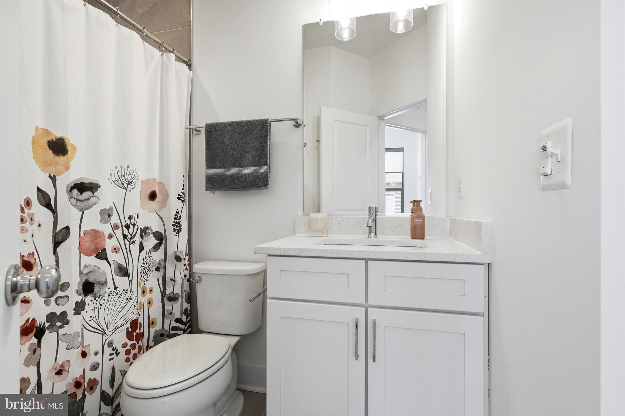 3311 Streamlet Lane Laurel, MD 20724 - Photo 36 of 46 a bathroom with a sink a toilet and shower curtain