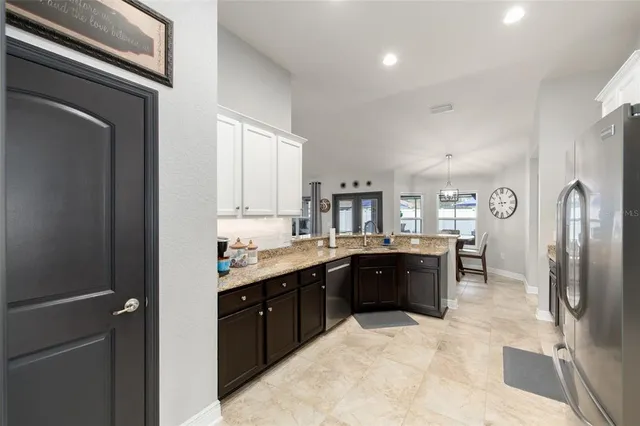 a large kitchen with a stove a refrigerator and a sink