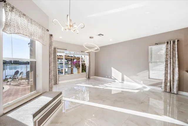 a view of a hallway with a large window and chandelier