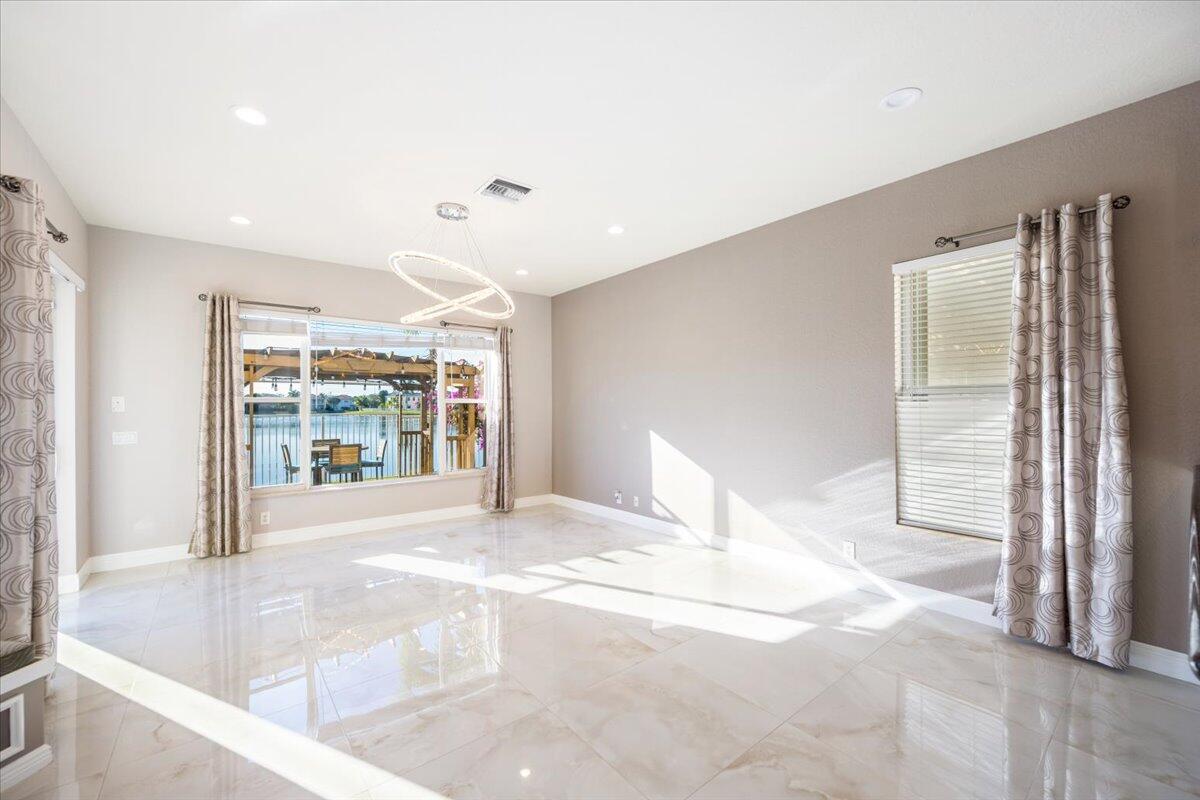 1238 Bay View Way Wellington, FL 33414 - Photo 17 of 39 a view of an empty room with a fireplace and a large window