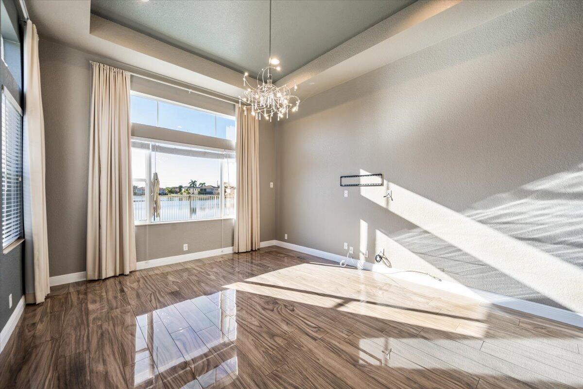 1238 Bay View Way Wellington, FL 33414 - Photo 21 of 39 a bedroom with a large bed and a chandelier