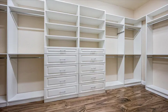 a view of walk in closet with empty racks