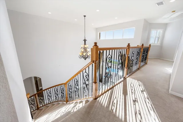 a view of a hallway with wooden floor and windows