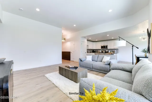 a living room with furniture white walls and a flat screen tv