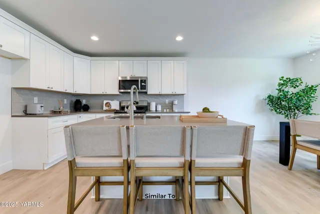 a kitchen with kitchen island a dining table and chairs