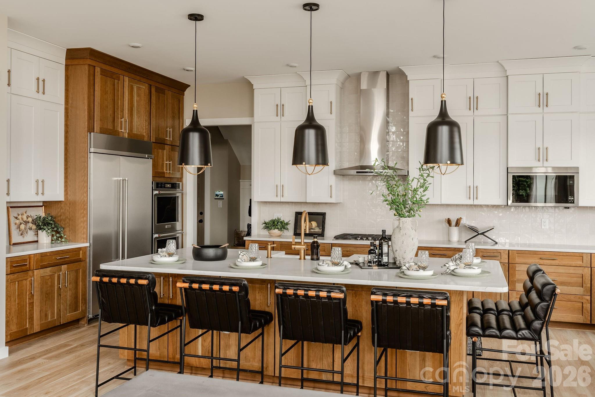 200 Ervin Road, Unit DEVONSHIRE Mooresville, NC 28117 - Photo 14 of 46 a kitchen with stainless steel appliances granite countertop a refrigerator a sink dishwasher a dining table and chairs with wooden floor