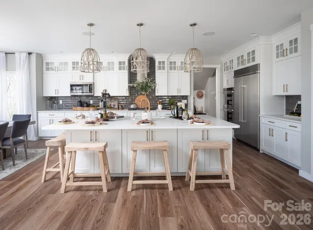 a large kitchen with a table chairs and a view of living room