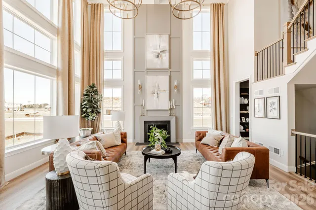 a living room with furniture fireplace and large windows