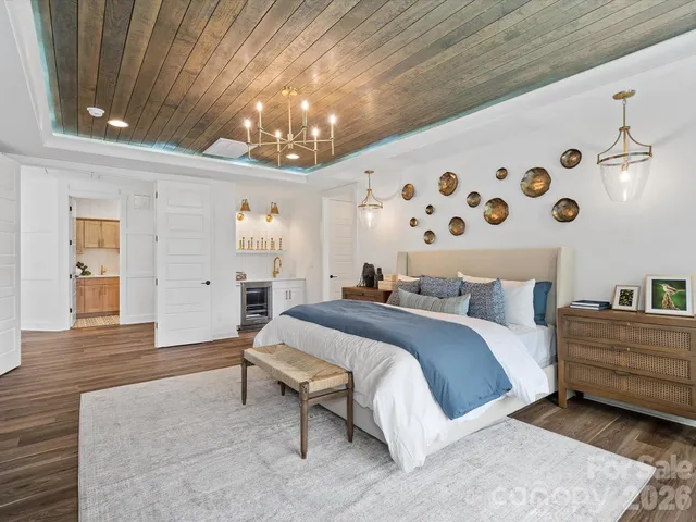 a spacious bedroom with a bed and a chandelier