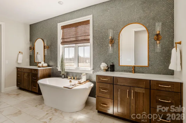 a bathroom with a double vanity sink a mirror and a bathtub