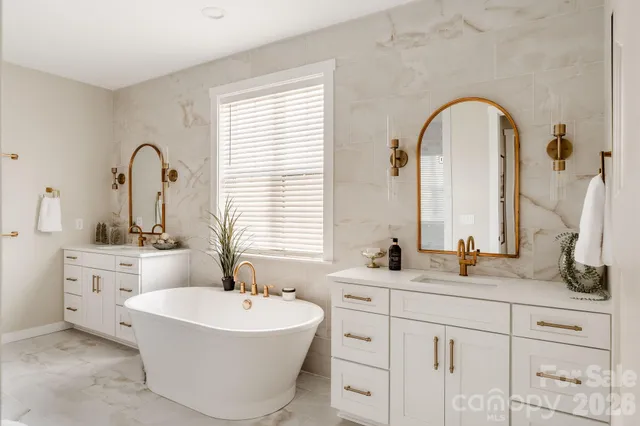 a bathroom with a double vanity sink mirror and bathtub