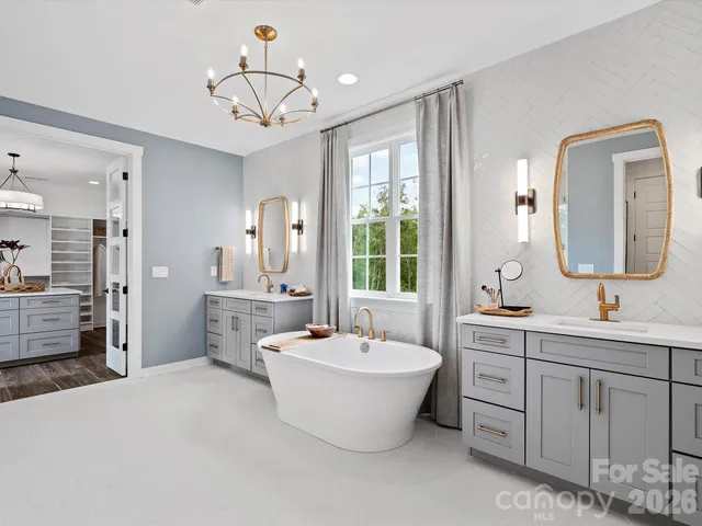 a bathroom with a double vanity sink mirror and bathtub