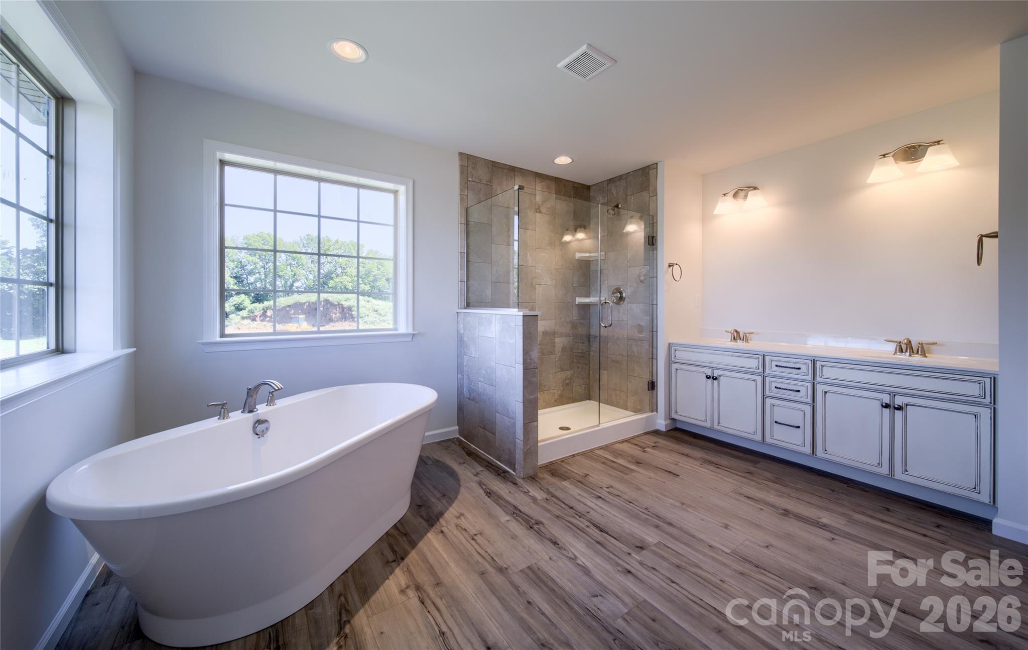 200 Ervin Road, Unit DEVONSHIRE Mooresville, NC 28117 - Photo 42 of 46 a spacious bathroom with a double vanity sink a mirror and a bathtub