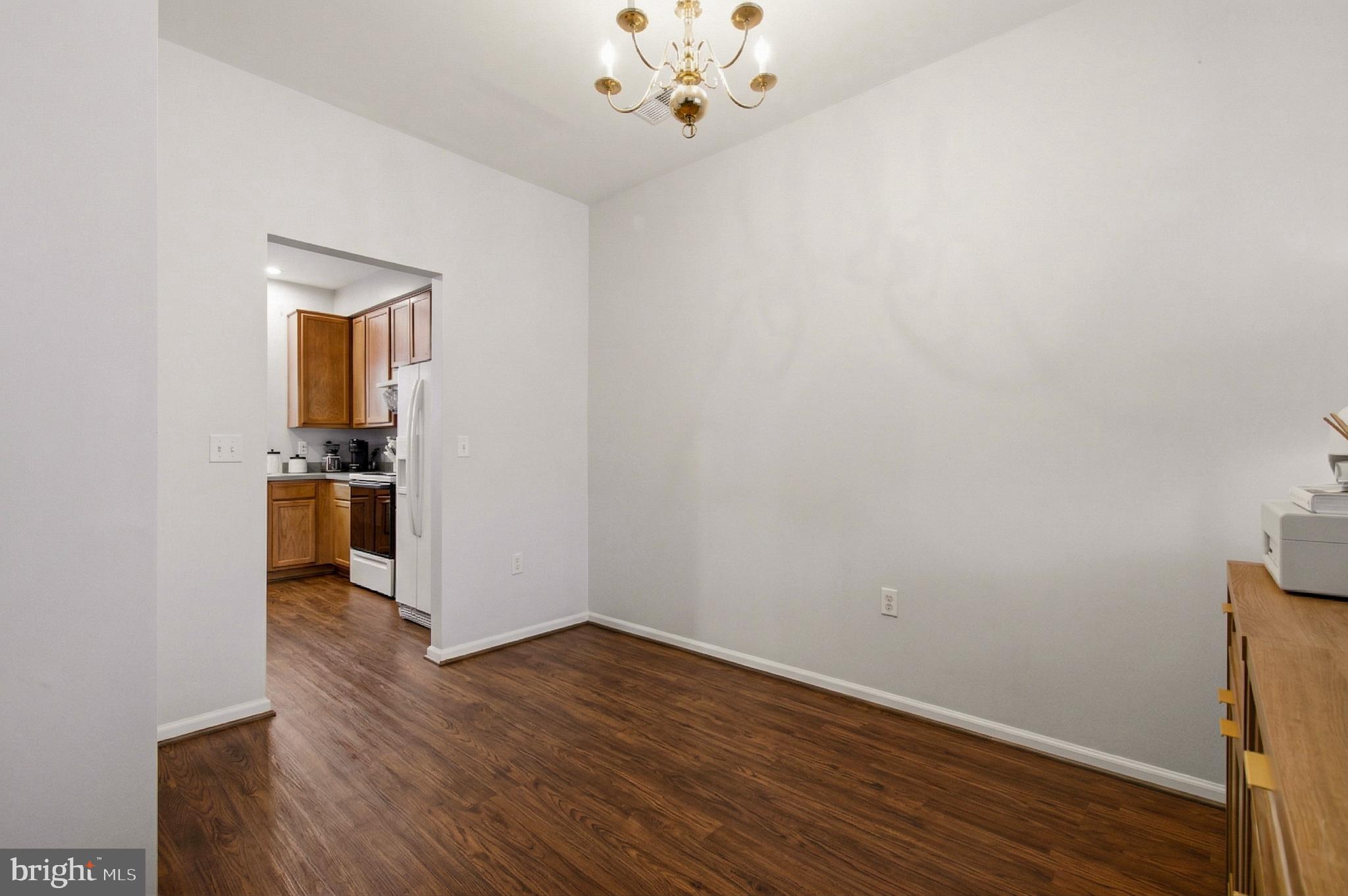 1212 Needham Court Crofton, MD 21114 - Photo 14 of 47 a view of a hallway with wooden floor and a chandelier